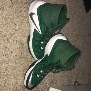 Green, black, and white Nike basketball shoes